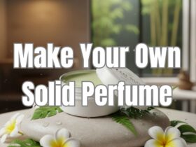 photo depiction of a tin of solid perfume balm on a smooth stone with white flowers surrounding it.